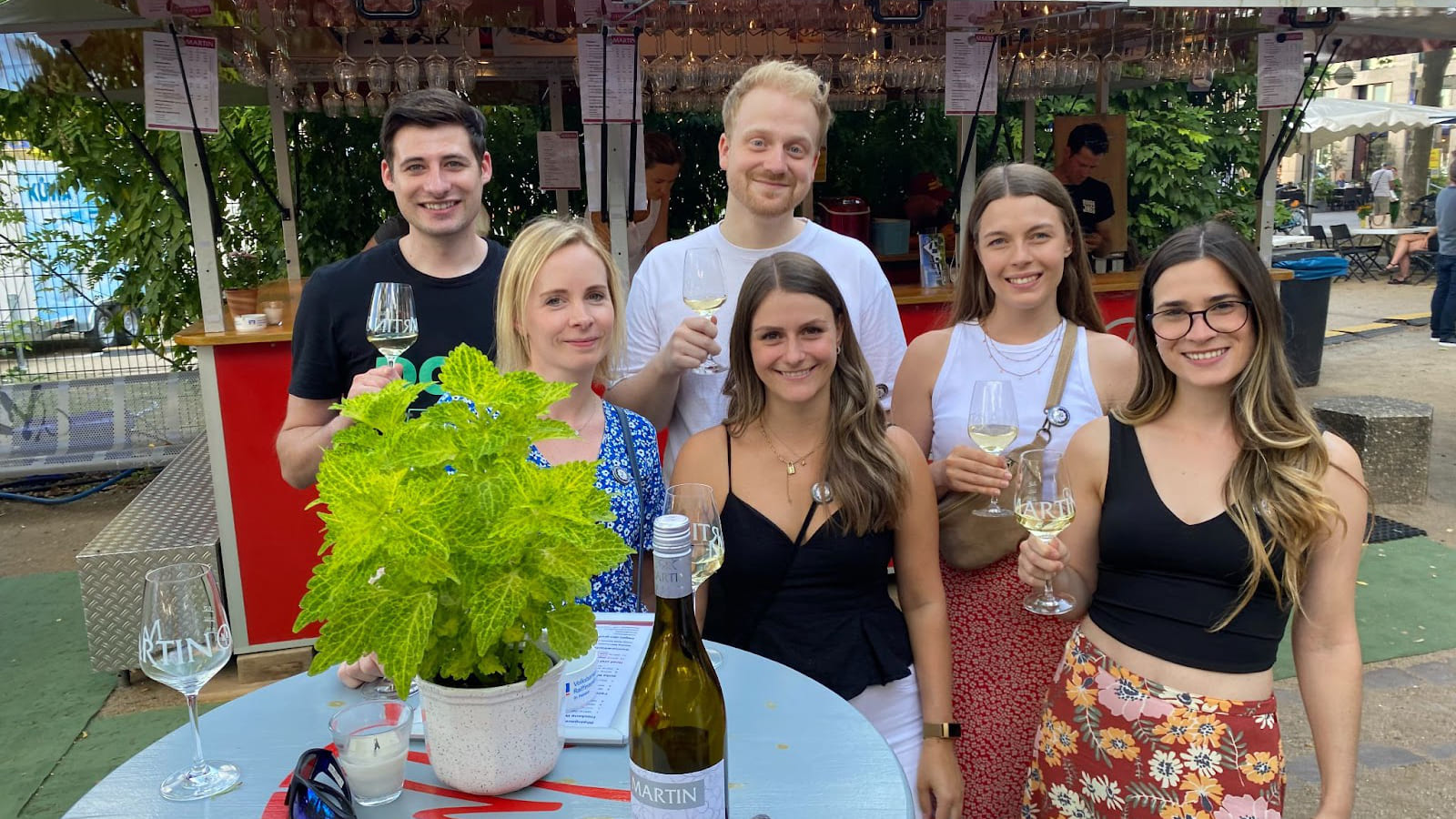 Nach vielen digitalen Events endlich wieder eine "physische" Veranstaltung: Ein Foto von sechs Mitarbeiterinnen und Mitarbeitern von Seibert Media, wie sie Gläser mit Weißwein halten und lächeln.